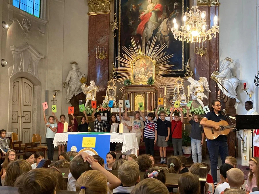 Messe in der Kirche, Kinder halten die Buchstaben mit dem Schriftzug "Josef Calasanz" über ihre Küpfe.